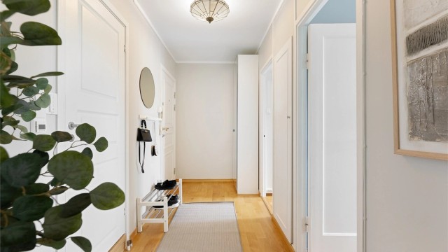 Innbydende entré med parkett på gulv og plass til garderobeskap.