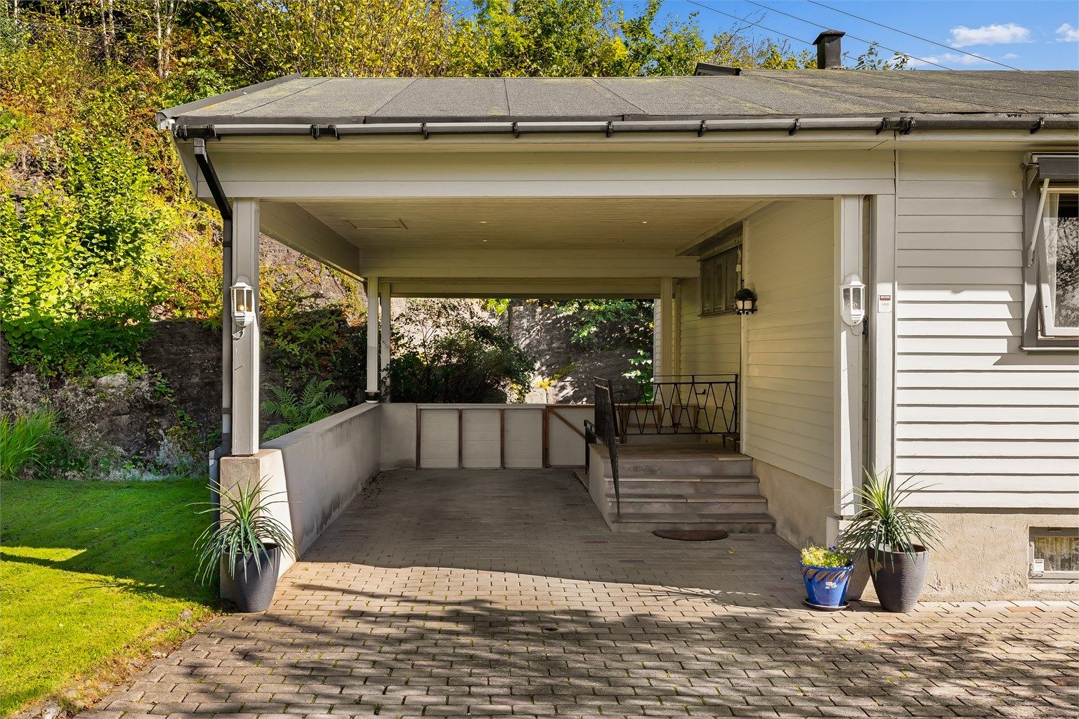 Carporten ble bygget på huset i 1999 og har dekke av belegningsstein.