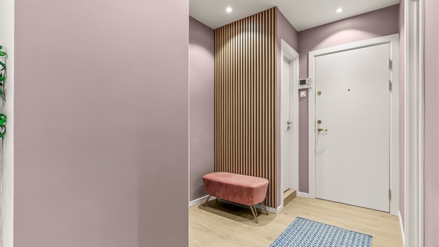En spilevegg i tre gir en lun og moderne detalj i entreen.