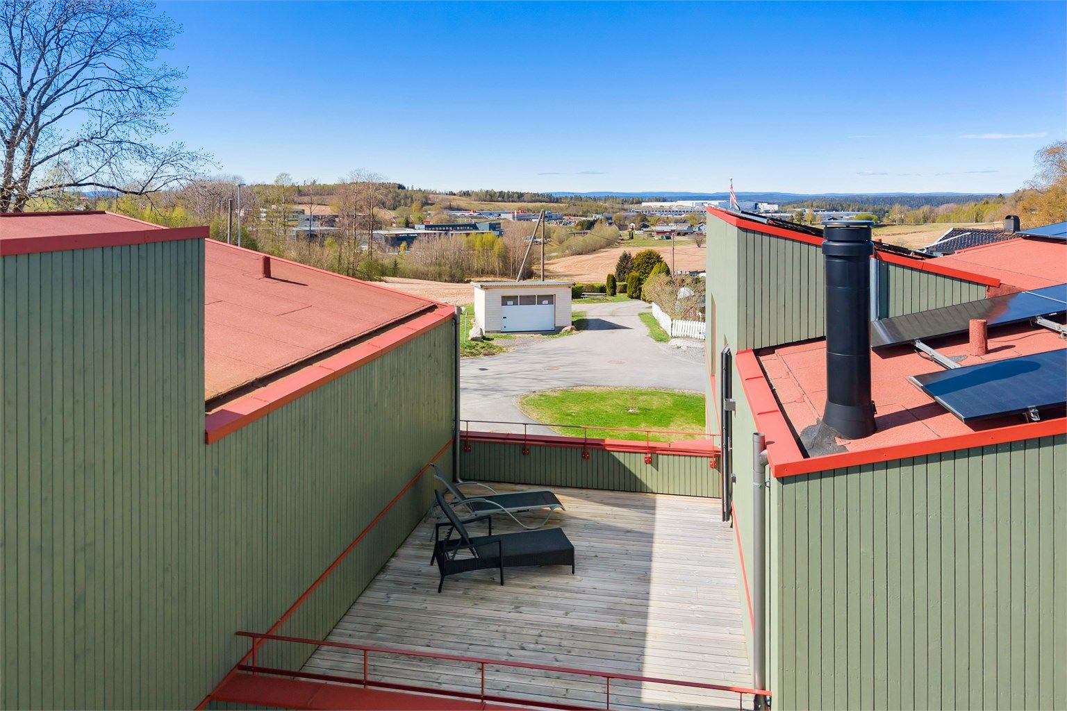 Utsikt fra takterrassen mot de grønne omgivelsene.
