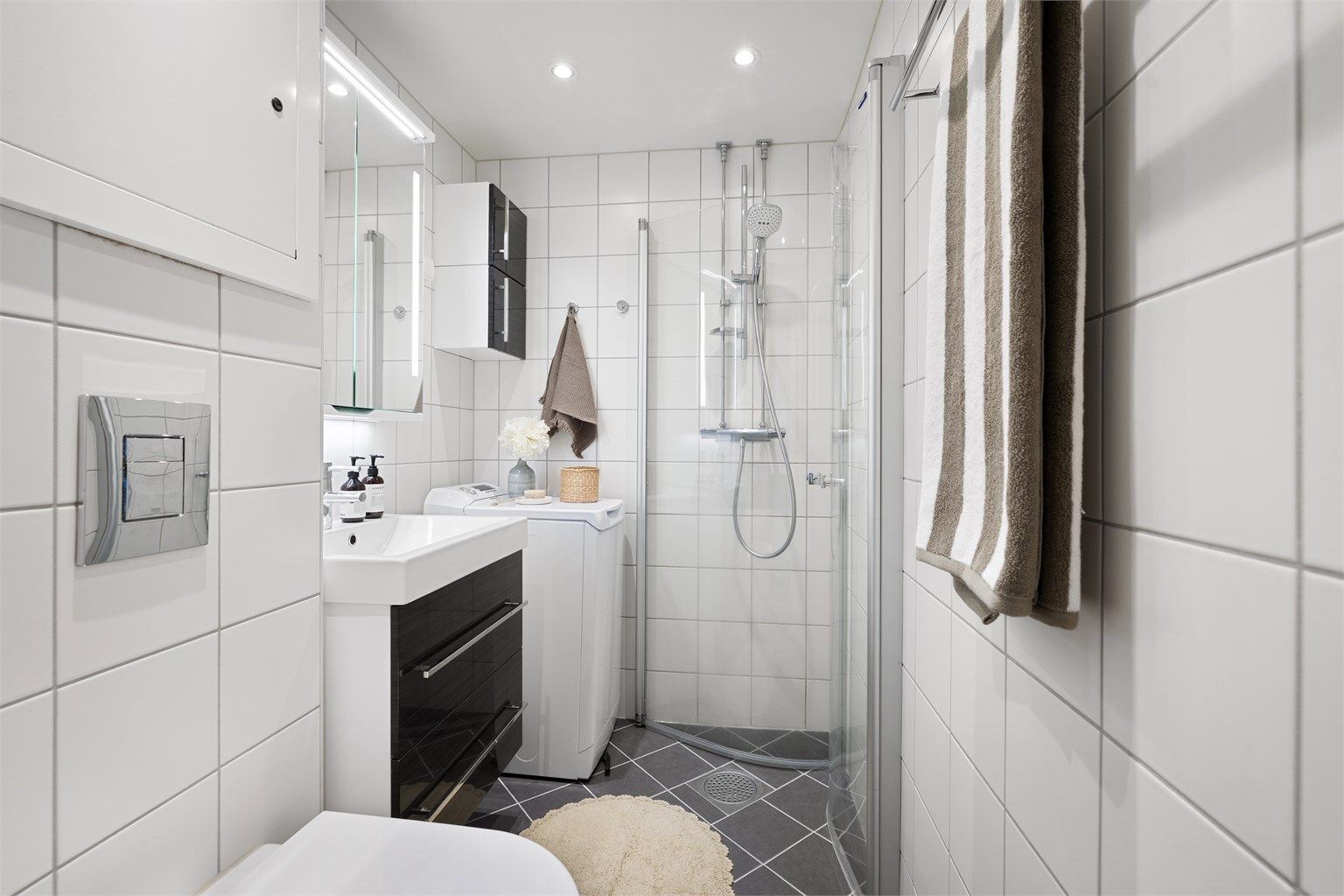  Himling med malte plater, innfelte downlights. Gulv med fliser og elektrisk gulvvarme. Innredet med vegghengt klosett, servant med innredning, speilskap med lys og dusjhjørne med svingbare glassdører. Opplegg for vaskemaskin. Mekanisk avtrekk