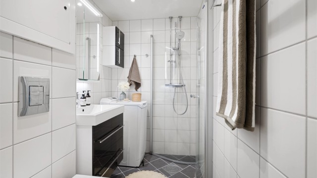 Himling med malte plater, innfelte downlights. Gulv med fliser og elektrisk gulvvarme. Innredet med vegghengt klosett, servant med innredning, speilskap med lys og dusjhjørne med svingbare glassdører. Opplegg for vaskemaskin. Mekanisk avtrekk