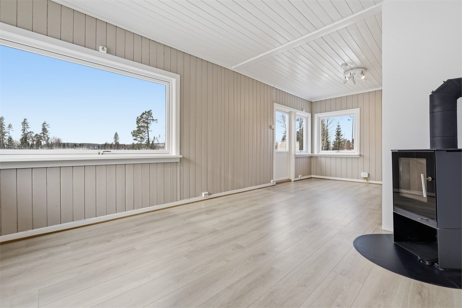 I stuen er det plass til flere sittegrupper. Her finner du peis som gir rikelig med varme. 