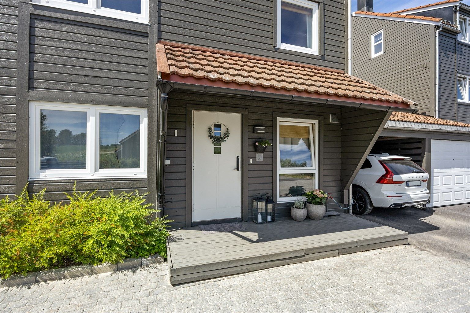 Parkering i carport med tilhørende boder.