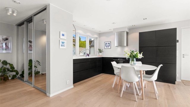 Kjøkkeninnredning fra Kvik med glatte, mørke fronter og benkeplate i Corian.