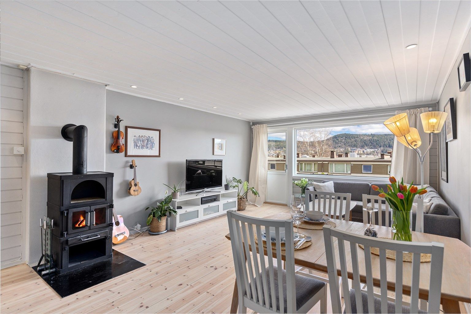 I stuen er det plass til både en spisegruppe og sofahjørne med tilhørende mediemøblement. Rommet har også en koselig peis som gir god varme til rommet