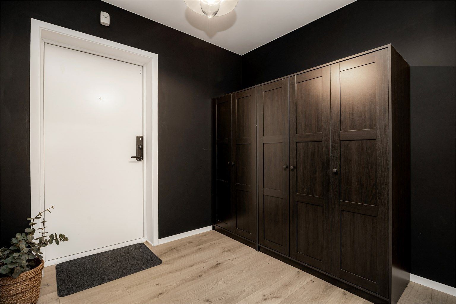 Entré med garderobeløsning med to garderobeskap i mørk og profilert utførelse