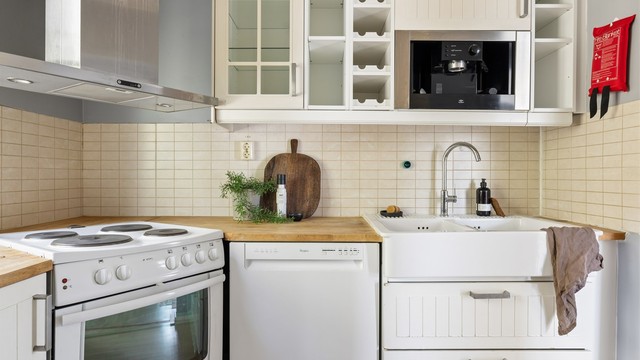Detaljer som vitrineskap og fliser over benken gir kjøkkenet karakter. Det er opplegg for oppvaskmaskin.