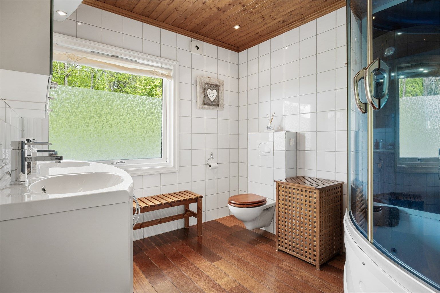 Badet er utstyrt med vegghengt toalett og dusjkar med flere funksjoner.