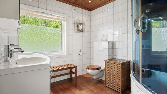 Badet er utstyrt med vegghengt toalett og dusjkar med flere funksjoner.