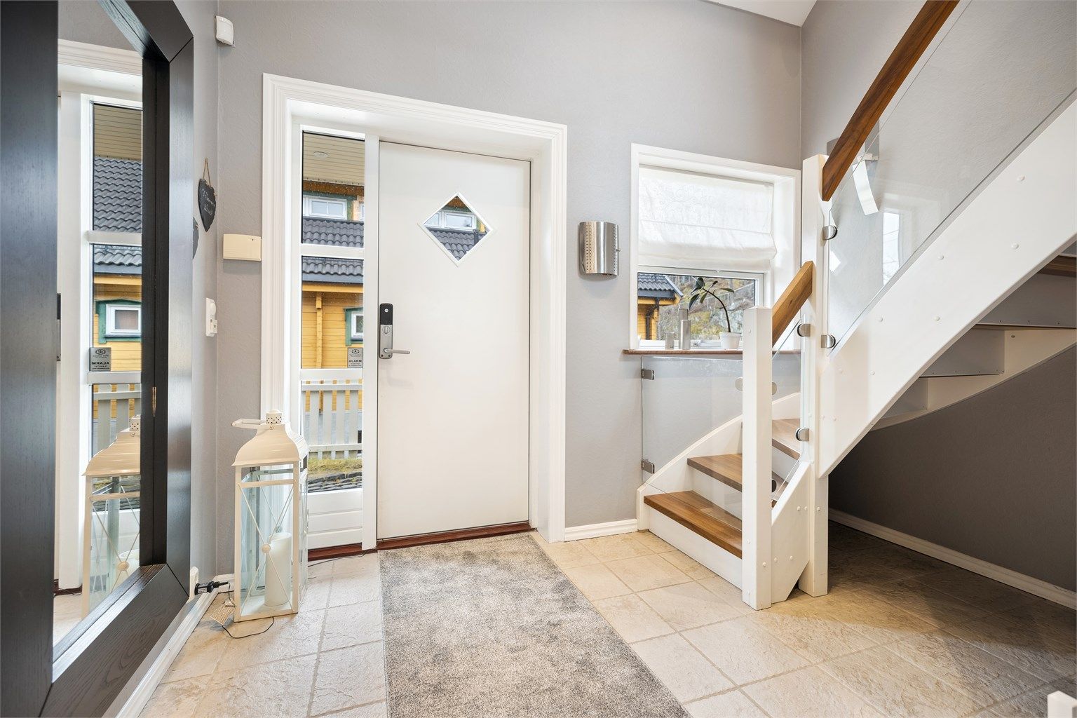 Romslig og lys entré med fliser på gulv med varme.