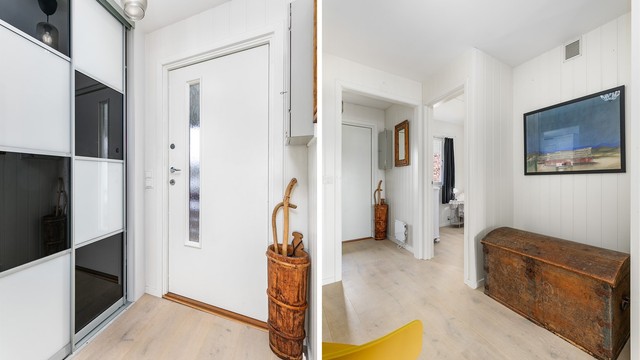 Laminatgulvet er lagt gjennomgående og terskelfritt mellom stuen, entreen og soverom II. I entreen kan yttertøyet oppbevares lett tilgjengelig i skyvedørsgarderobe.