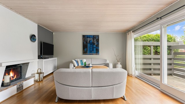 Stuen har en peis som gir ekstra varme og hygge. Gulvet er belagt med parkett.