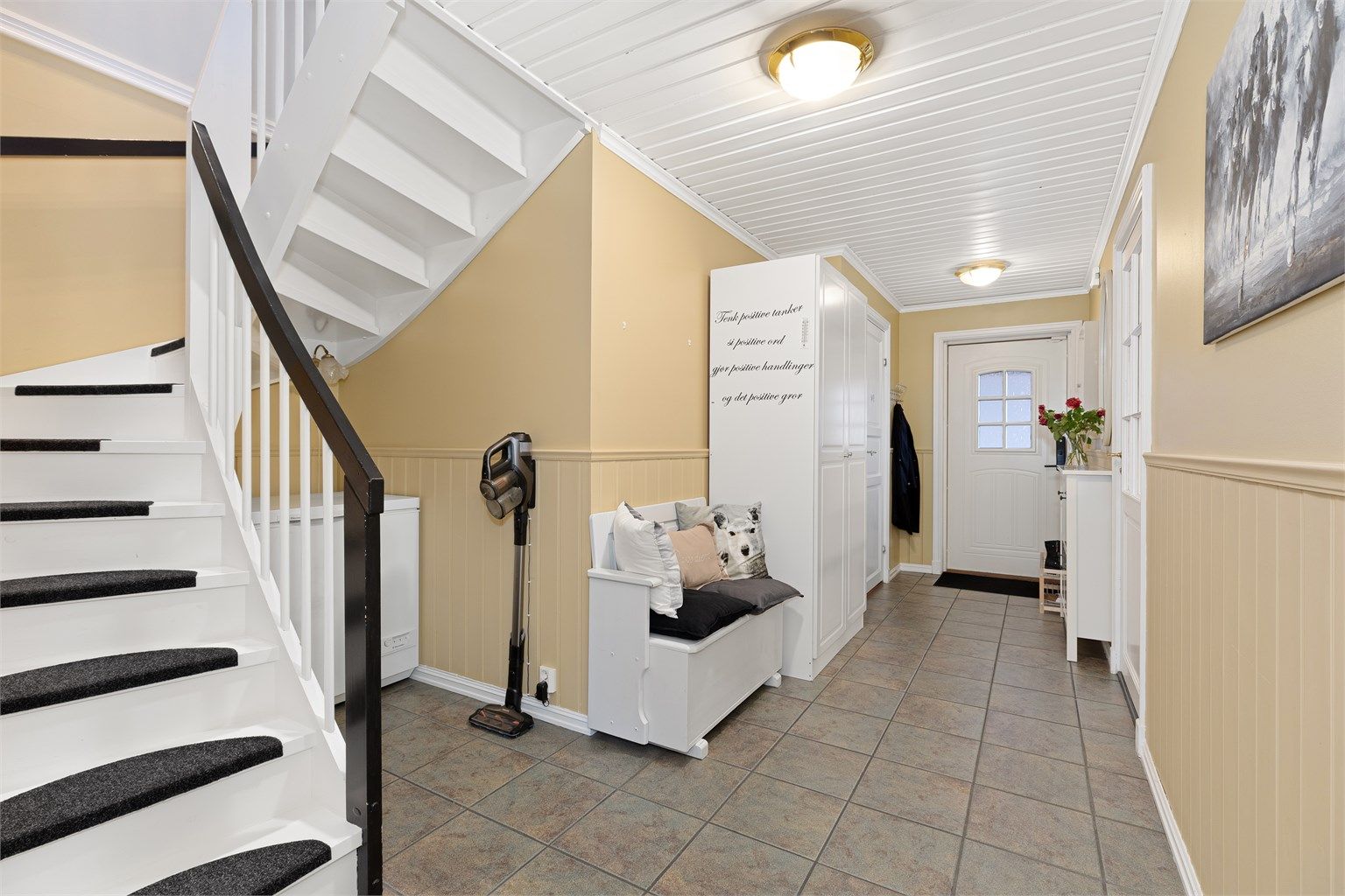 Det er varmekabler i gulv i gangen. Fra gangen ser vi til høyre i bildet inngang til kjøkken, og nederst til venstre inngang til vaskerom/toalettrom