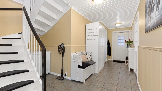 Det er varmekabler i gulv i gangen. Fra gangen ser vi til høyre i bildet inngang til kjøkken, og nederst til venstre inngang til vaskerom/toalettrom