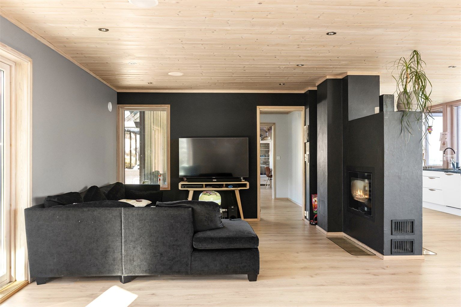 En sentralt plassert peisovn med glassdør gir ekstra varme og atmosfære i stuen.