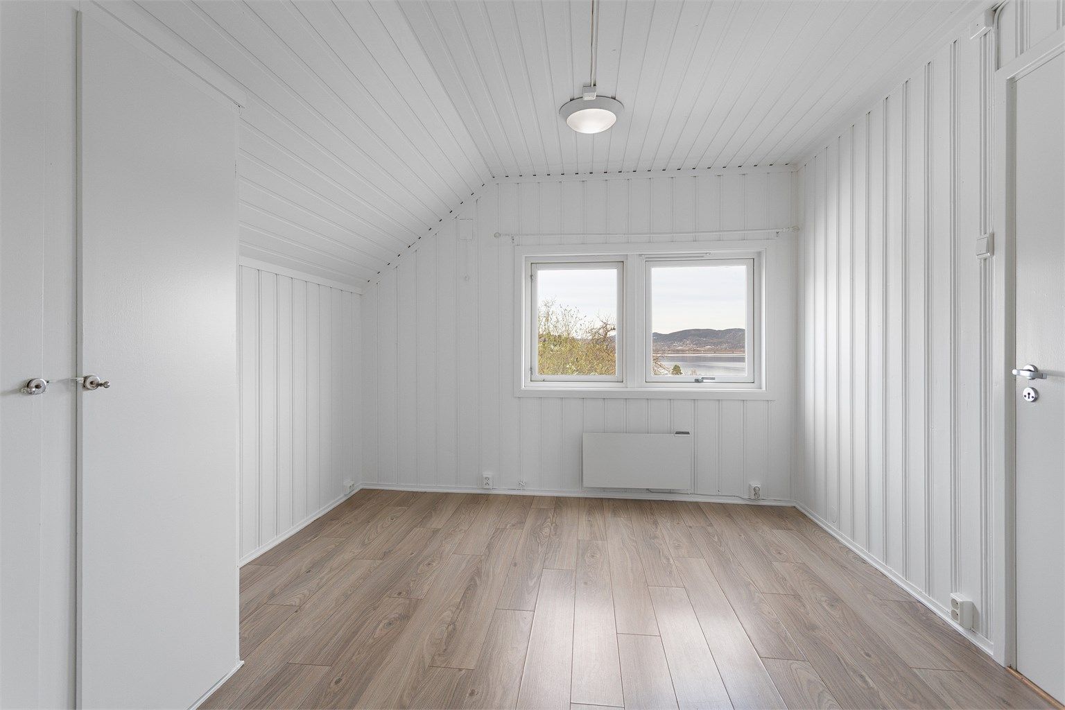 Soverommet i 3. etasje har laminatgulv og malt panel, i likhet med resten av leiligheten.