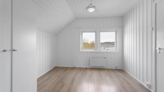 Soverommet i 3. etasje har laminatgulv og malt panel, i likhet med resten av leiligheten.