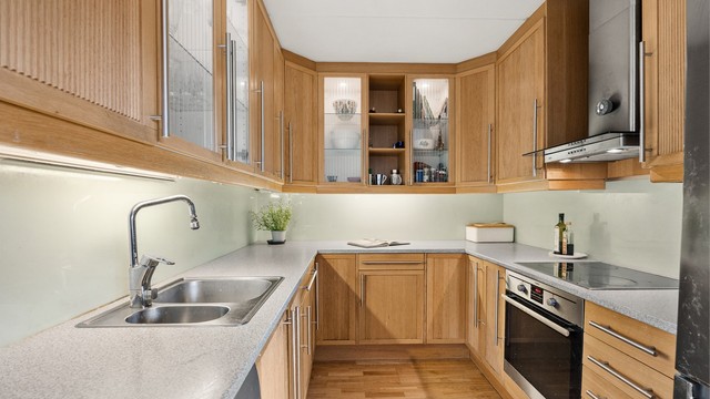 Kjøkkeninnredning med glatte og profilerte fronter samt laminert benkeplate.