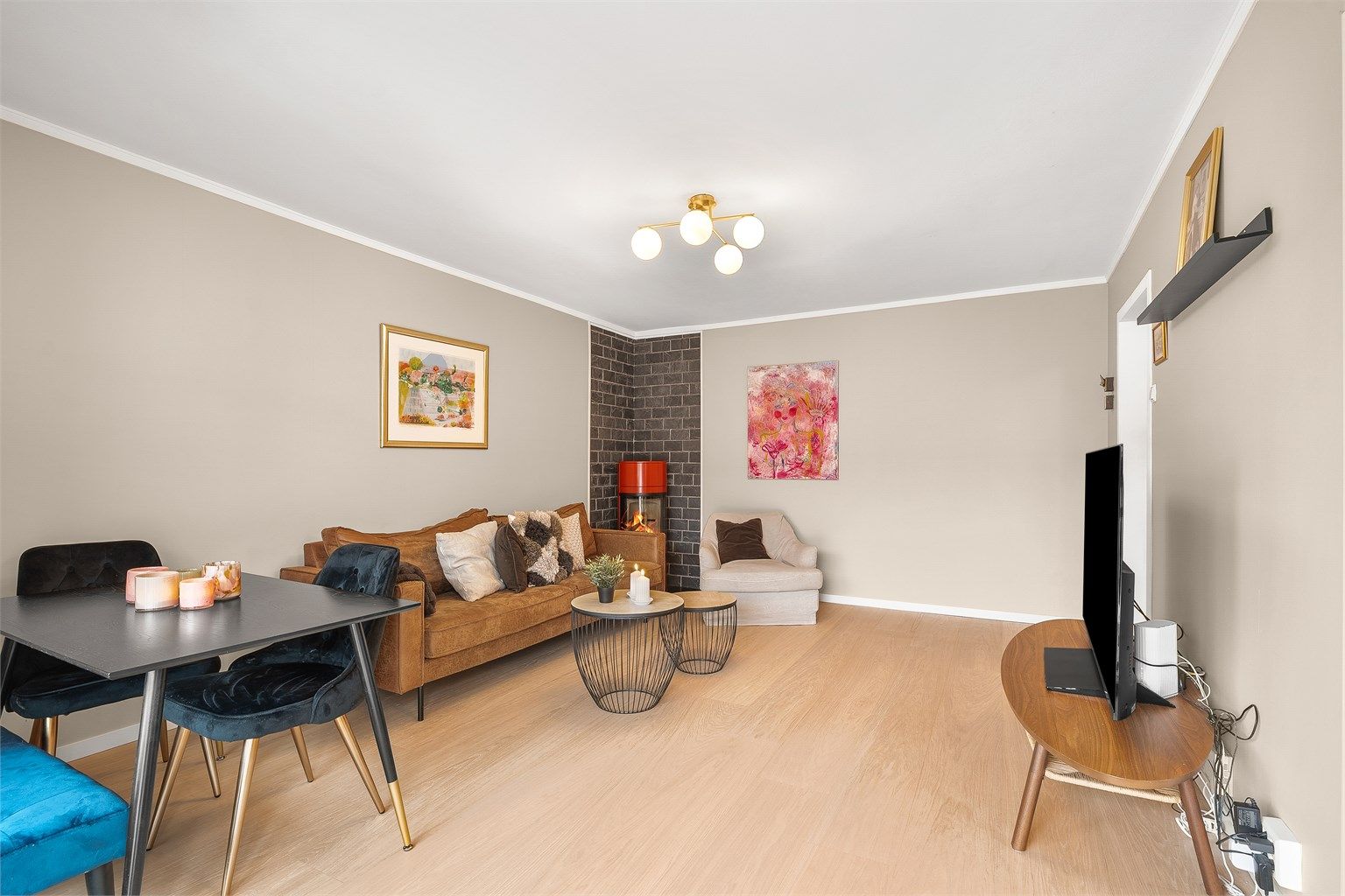 Frittstående peisovn med plate på gulv og skiferbelagt vegg, pent plassert i hjørnet av rommet.