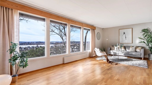 Stuen bader i dagslys fra store vinduer med utsikt du aldri blir lei av.