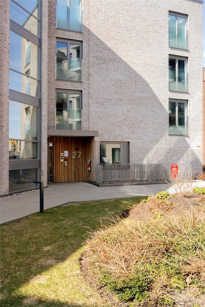 Bygget har en moderne fasade med en kombinasjon av teglstein og trekledning.