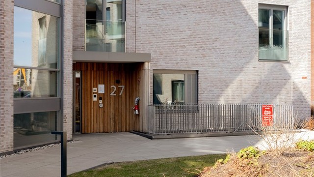 Bygget har en moderne fasade med en kombinasjon av teglstein og trekledning.