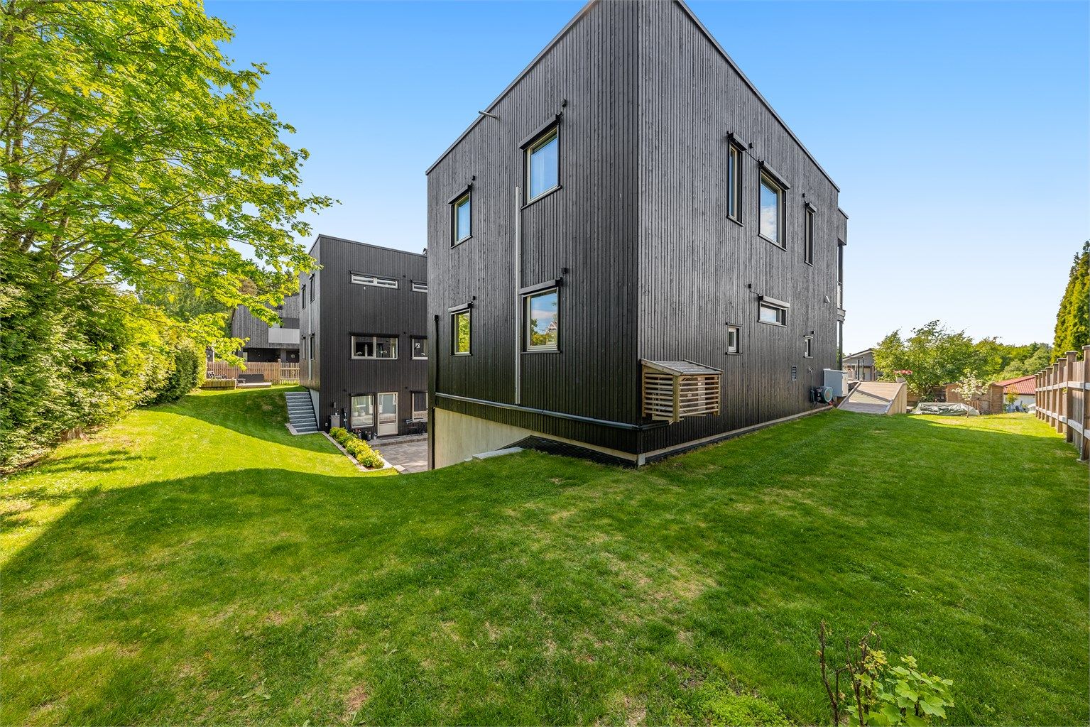 Eiendommen har en pent opparbeidet hage og ligger i et skrånende terreng.
