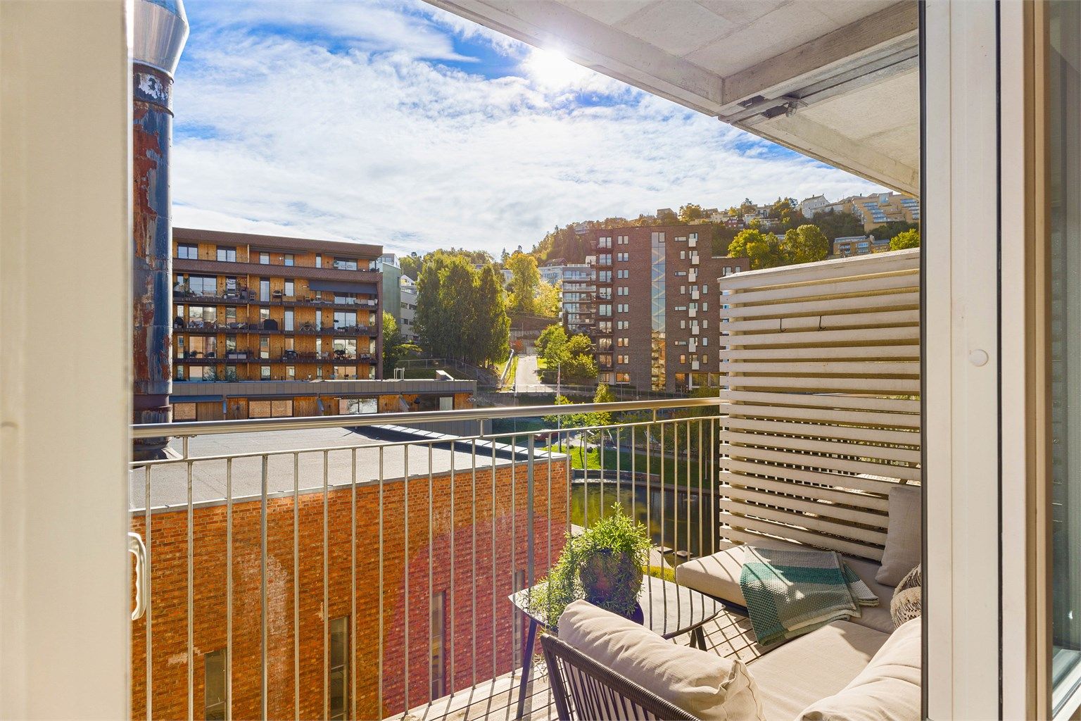 Balkongen blir en naturlig forlengelse av stuen gjennom sommerhalvåret. Fra 4. etasje får du et luftig utsyn over de grønne fellesområdene og det karakteristiske vannspeilet i Kværnerbyen.