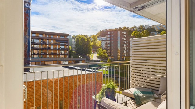 Balkongen blir en naturlig forlengelse av stuen gjennom sommerhalvåret. Fra 4. etasje får du et luftig utsyn over de grønne fellesområdene og det karakteristiske vannspeilet i Kværnerbyen.