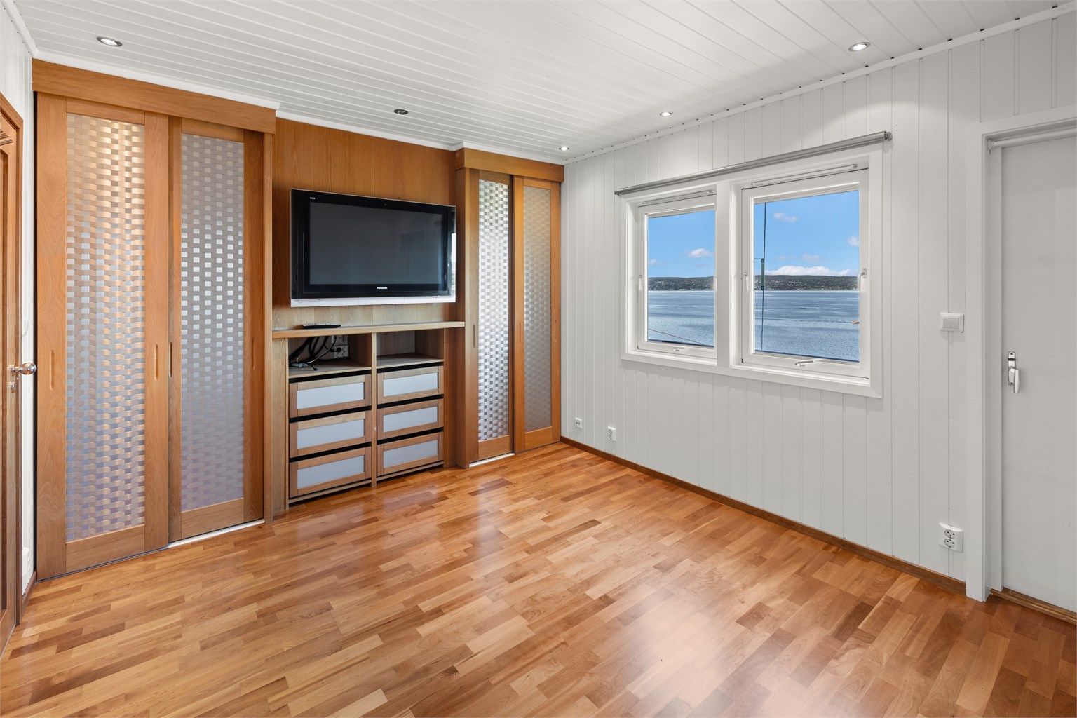 Det ene soverommet i loftsetasjen har skyvedørsgarderobe og downlights.