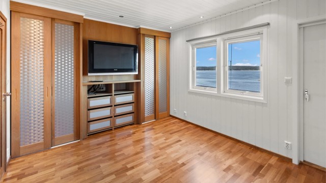 Det ene soverommet i loftsetasjen har skyvedørsgarderobe og downlights.