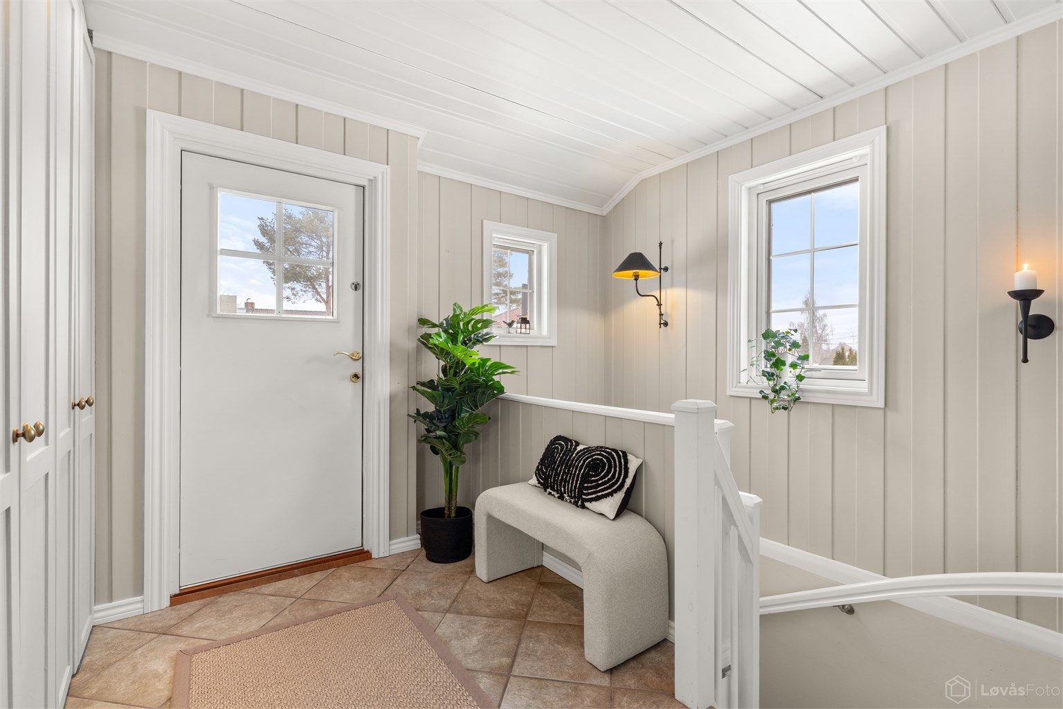 Romslig entré med gulvfliser med varmekabler og lys malt panel på vegger og i tak som gir et hyggelig førsteinntrykk. God plass til yttertøy i plassbygget garderobeskap. Utenfor ytterdøren er det også varmekabler i trapp/platting ved inngangspartiet