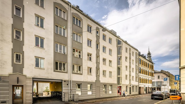 Fasade fra gaten. Leiligheten ligger tilbaketrukket til ved enveiskjørt gate.
