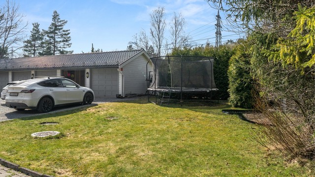 Parkering i garasje i felles garasjerekke for sameiet. Fastmontert lader for EL-bil følger med.