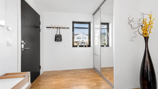 Entre/inngangsparti med skyvedørsgarderobe og gode oppbevaringsmuligheter for yttertøy og sko