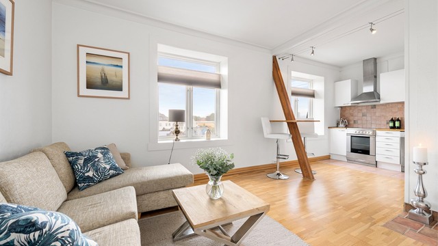 Stuen har en åpen løsning mot kjøkkenet, med plass til en hyggelig sofagruppe.