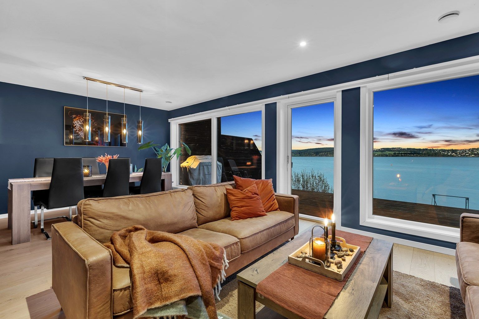 Moderne stue med downlights i himling, varmepumpe og store vinduer som slipper inn rikelig med naturlig lys