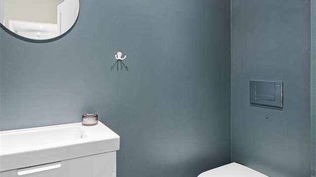 I tilknytning til entréen er det et praktisk toalettrom. Det er varmekabler i det flislagte gulvet og nedsenket himling med downlights.