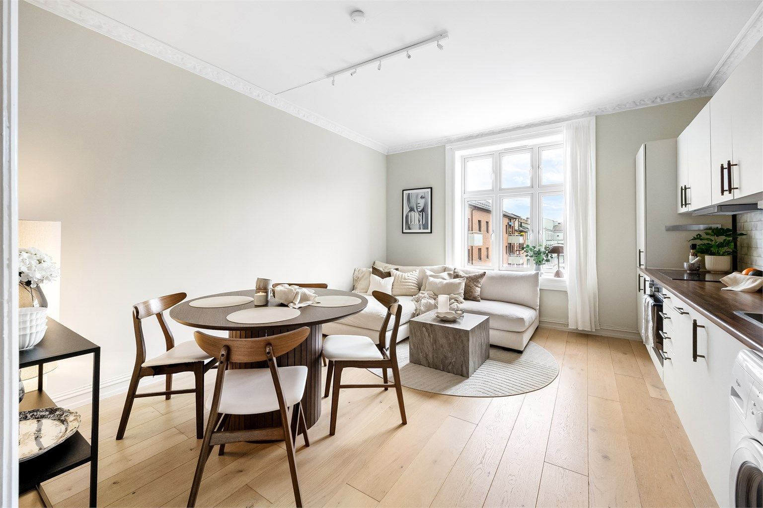 En lys, romslig og innbydende stue med åpen kjøkkenløsning.