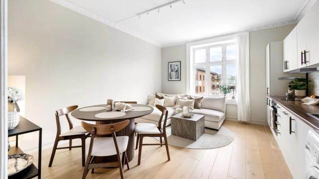 En lys, romslig og innbydende stue med åpen kjøkkenløsning.