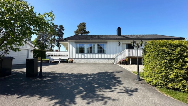 Velkommen til Blindveien1 | Boligen har et veldig praktisk uteområde, asfaltert med noe varmekabler, dobbel garasje med lader, enkel adkomst inn i bolig og garasje