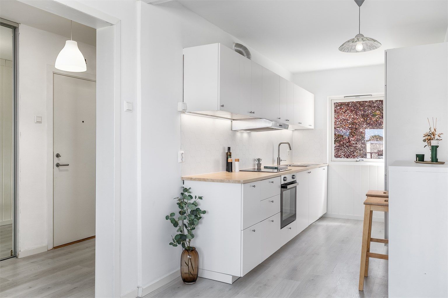 Kjøkkenet er åpnet mot stuen og oppgradert med helt ny innredning fra IKEA. Laminatgulvet er lagt gjennomgående og skaper helhet.