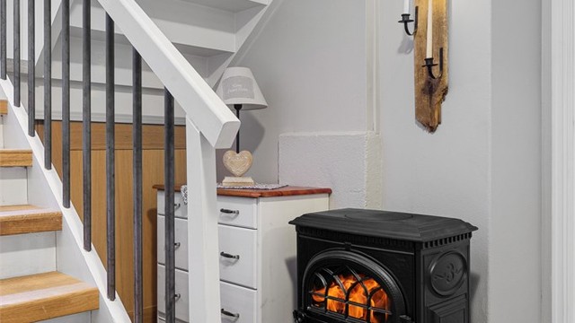 En vedovn ved trappen i underetasjen gir ekstra varme og hygge.