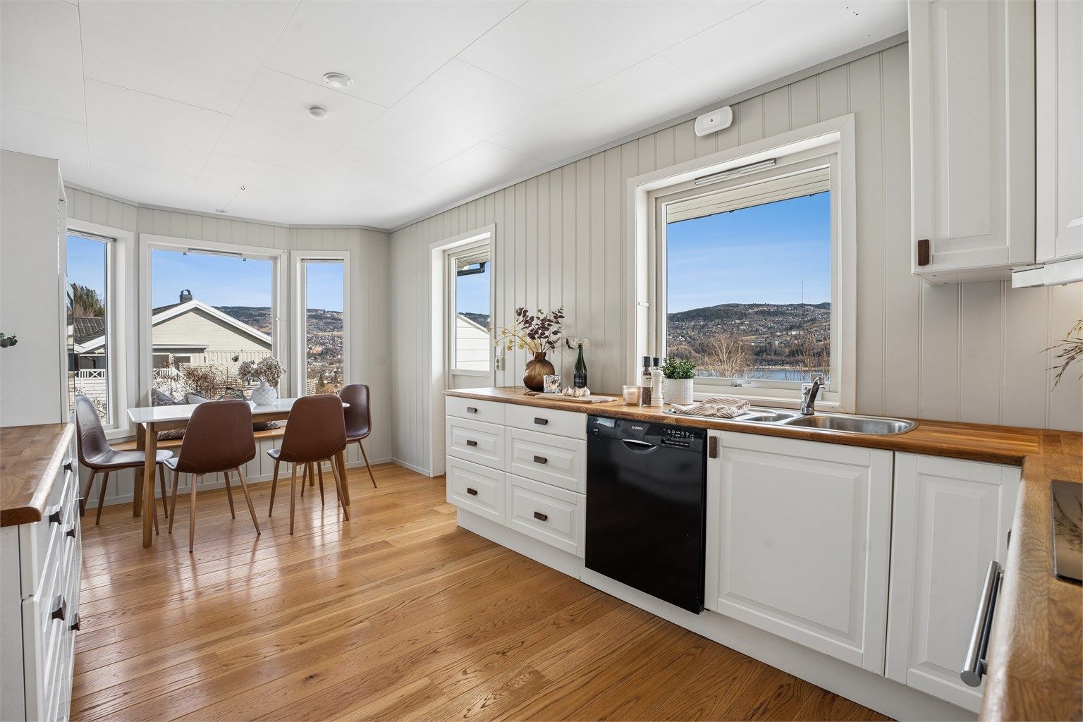 Kjøkkenet har profilerte fronter, benkeplate i tre og integrerte hvitevarer, og ligger i naturlig tilknytning til spisestuen.