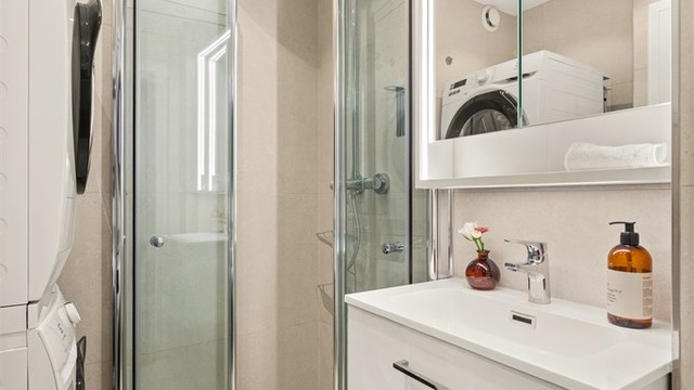 Videre har badet dusjhjørne og vegghengt toalett med innebygget sisterne. Det er opplegg for vaskemaskin.