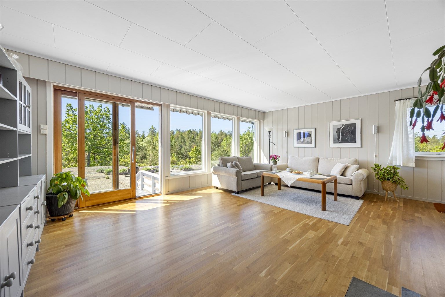 Stuen i første etasje har parkettgulv og store vindusflater. Skyvedør gir direkte utgang til en markterrasse på 11 m².