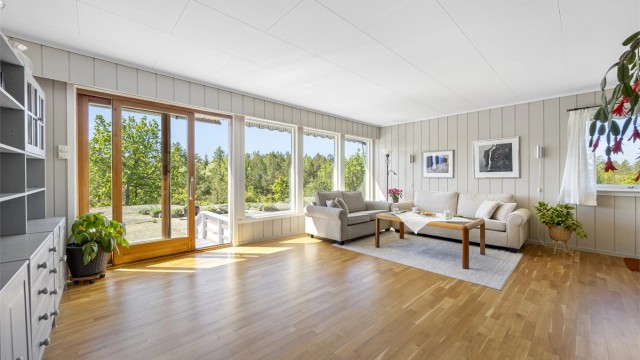Stuen i første etasje har parkettgulv og store vindusflater. Skyvedør gir direkte utgang til en markterrasse på 11 m².