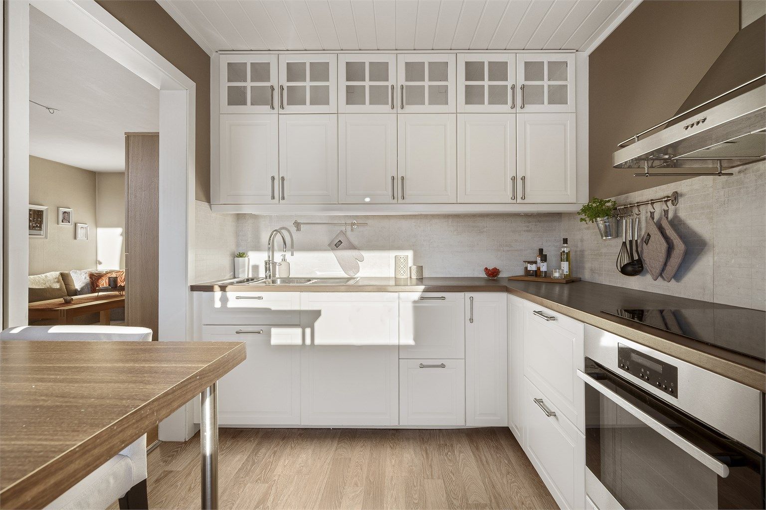 Stilrent kjøkken med profilerte fronter og moderne hvitevarer.