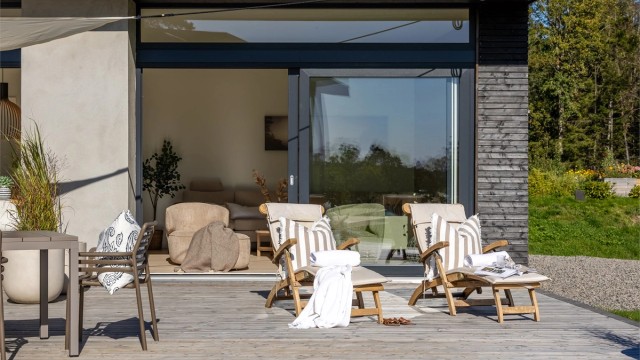De store skyvedørene skaper en sømløs overgang mellom stue og terrasse.